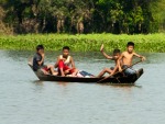 Waving children on a wooden boat