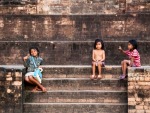 Cambodian girls sitting at the base of Kravan Temple