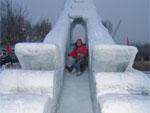 Sonya and I (barely visible) sliding down an ice slide at the entrance of Harbin Polarland