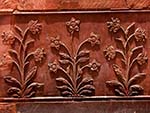 Intricate carved flowers in the red sandstone