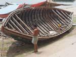 A boat builder with his wooden boat