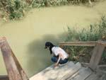 Baptism Site of Jesus - Sonya touching the Jordan River
