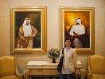 Sonya with portraits of Sheikhs at the Emirates Palace
